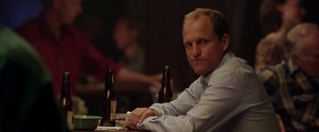 Movie still from “North Country” (2005), directed by Niki Caro – A man sitting at a table in front of two bottles of beer; Close Up shot, Over the shoulder angle