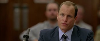 Movie still from “North Country” (2005), directed by Niki Caro – A man in a suit and tie sitting in front of a microphone; Close Up shot, Over the shoulder angle