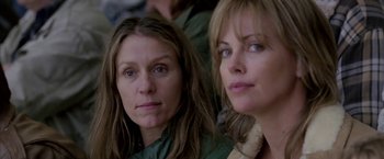 Movie still from “North Country” (2005), directed by Niki Caro – Two women sitting next to each other in front of a wall; Close Up shot, Over the shoulder angle