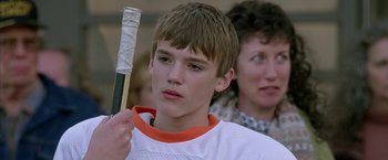Movie still from “North Country” (2005), directed by Niki Caro – A young man holding a baseball bat in front of a woman; Close Up shot, Low angle