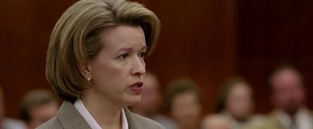 Movie still from “North Country” (2005), directed by Niki Caro – An older woman in a gray suit is speaking to a group of people; Close Up shot, Low angle