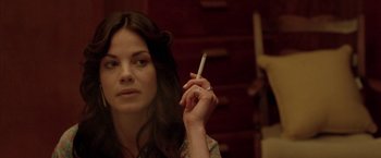 Movie still from “North Country” (2005), directed by Niki Caro – A woman is holding a cigarette in her hand; Close Up shot, Over the shoulder angle