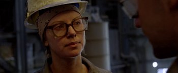 Movie still from “North Country” (2005), directed by Niki Caro – A woman wearing glasses and wearing a hard hat; Close Up shot, Over the shoulder angle