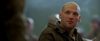 Movie still from “North Country” (2005), directed by Niki Caro – A man with a bald head is looking to his left; Close Up shot, Low angle