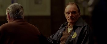 Movie still from “North Country” (2005), directed by Niki Caro – An older man sitting in front of a camera; Close Up shot, Over the shoulder angle