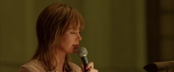 Movie still from “North Country” (2005), directed by Niki Caro – A woman holding a microphone up to her mouth; Close Up shot, Low angle