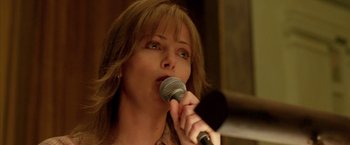 Movie still from “North Country” (2005), directed by Niki Caro – A person holding a microphone up to their mouth; Close Up shot, Low angle