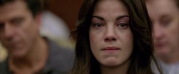 Movie still from “North Country” (2005), directed by Niki Caro – A woman's face with a sad look on her face; Close Up shot, Over the shoulder angle