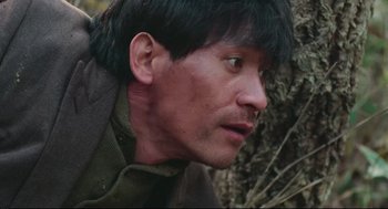 Movie still from “North Korean Partisan in South Korea” (1990), directed by Jeong Ji-yeong – A person wearing a jacket; Close Up shot, Low angle