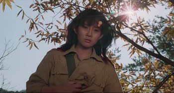 Movie still from “North Korean Partisan in South Korea” (1990), directed by Jeong Ji-yeong – A person standing in front of a tree; Medium shot, Low angle