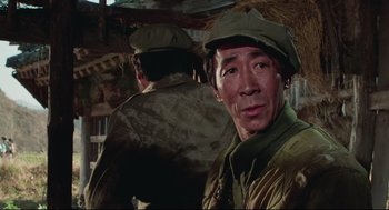 Movie still from “North Korean Partisan in South Korea” (1990), directed by Jeong Ji-yeong – A man in a hat and a uniform; Close Up shot, Low angle