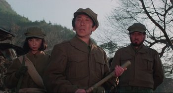 Movie still from “North Korean Partisan in South Korea” (1990), directed by Jeong Ji-yeong – A group of men in military uniforms holding a baseball bat; Medium shot, Low angle