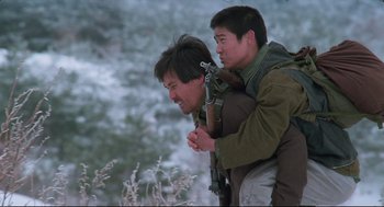Movie still from “North Korean Partisan in South Korea” (1990), directed by Jeong Ji-yeong – Two men are riding on top of each other in the snow; Medium shot, Low angle