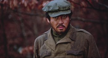 Movie still from “North Korean Partisan in South Korea” (1990), directed by Jeong Ji-yeong – A person wearing a hat; Close Up shot, Low angle