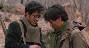 Movie still from “North Korean Partisan in South Korea” (1990), directed by Jeong Ji-yeong – Two men are looking at one another in the woods; Close Up shot, Low angle