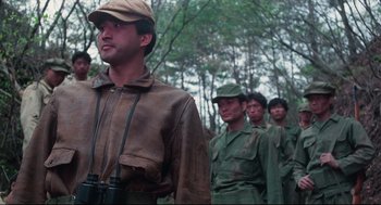 Movie still from “North Korean Partisan in South Korea” (1990), directed by Jeong Ji-yeong – A group of men standing next to each other in the woods; Medium shot, Low angle