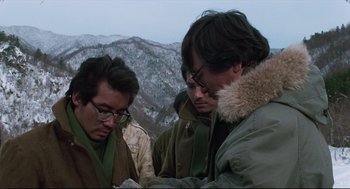 Movie still from “North Korean Partisan in South Korea” (1990), directed by Jeong Ji-yeong – A group of men standing next to each other on top of a hill; Close Up shot, Over the shoulder angle