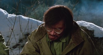 Movie still from “North Korean Partisan in South Korea” (1990), directed by Jeong Ji-yeong – A man in a green jacket and white glasses; Close Up shot, High angle
