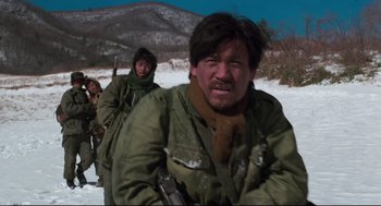 Movie still from “North Korean Partisan in South Korea” (1990), directed by Jeong Ji-yeong – A group of men in the snow with rifles; Medium shot, Low angle