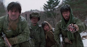 Movie still from “North Korean Partisan in South Korea” (1990), directed by Jeong Ji-yeong – A group of men in military fatigues are posing for a picture; Medium shot, Low angle