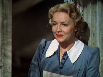 Movie still from “North West Mounted Police” (1940), directed by Cecil B. DeMille – An older woman with blonde hair wearing a blue dress; Close Up shot, Low angle