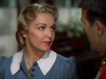 Movie still from “North West Mounted Police” (1940), directed by Cecil B. DeMille – An older woman wearing a blue dress with a white collar; Close Up shot, Over the shoulder angle