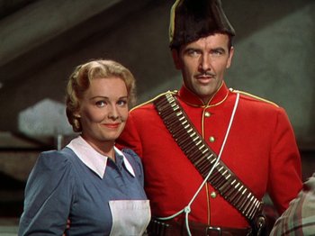 Movie still from “North West Mounted Police” (1940), directed by Cecil B. DeMille – A man and a woman posing for a picture; Medium shot, Low angle