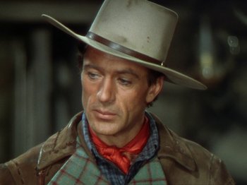Movie still from “North West Mounted Police” (1940), directed by Cecil B. DeMille – A man wearing a cowboy hat and a plaid shirt; Close Up shot, Over the shoulder angle
