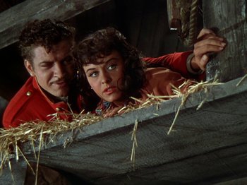 Movie still from “North West Mounted Police” (1940), directed by Cecil B. DeMille – A man and a woman are looking over a ledge; Medium shot, Low angle