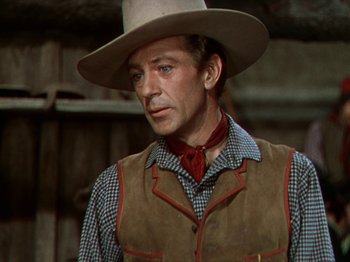 Movie still from “North West Mounted Police” (1940), directed by Cecil B. DeMille – A man wearing a cowboy hat and a vest; Close Up shot, Over the shoulder angle