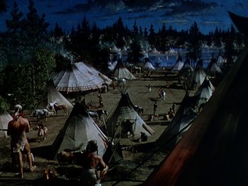 Movie still from “North West Mounted Police” (1940), directed by Cecil B. DeMille – A group of people standing around tents in a field; Extreme Wide shot, High angle