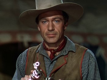 Movie still from “North West Mounted Police” (1940), directed by Cecil B. DeMille – A man wearing a cowboy hat and holding a gun; Close Up shot, Low angle