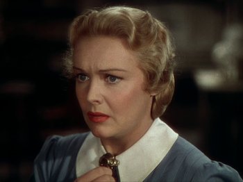 Movie still from “North West Mounted Police” (1940), directed by Cecil B. DeMille – An older woman is holding a neck tie; Close Up shot, Over the shoulder angle