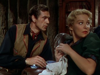 Movie still from “North West Mounted Police” (1940), directed by Cecil B. DeMille – A man and a woman sitting at a table; Medium shot, Over the shoulder angle