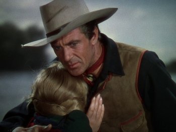Movie still from “North West Mounted Police” (1940), directed by Cecil B. DeMille – A man and a woman embracing each other in a cowboy hat; Medium shot, Over the shoulder angle