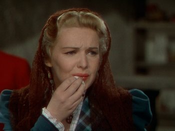 Movie still from “North West Mounted Police” (1940), directed by Cecil B. DeMille – A woman in a plaid shirt and a red head scarf; Close Up shot, Over the shoulder angle