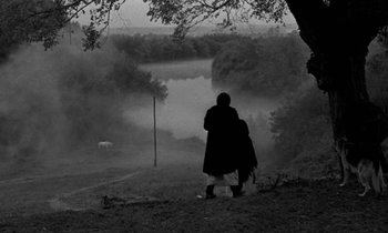 Movie still from “Nostalghia” (1983), directed by Andrei Tarkovsky – A man and a woman standing on top of a grass covered hill; Wide shot, High angle