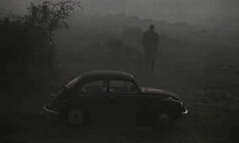 Movie still from “Nostalghia” (1983), directed by Andrei Tarkovsky – A car parked in the middle of a foggy field; Wide shot, High angle