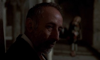 Movie still from “Nostalghia” (1983), directed by Andrei Tarkovsky – A person wearing a suit and tie; Close Up shot, Low angle