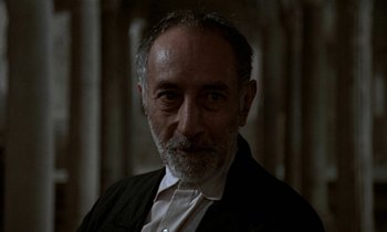 Movie still from “Nostalghia” (1983), directed by Andrei Tarkovsky – An older man wearing a white shirt and a black jacket; Close Up shot, Low angle