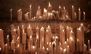Movie still from “Nostalghia” (1983), directed by Andrei Tarkovsky – A bunch of lit candles are in a room; Wide shot, High angle