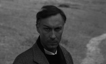 Movie still from “Nostalghia” (1983), directed by Andrei Tarkovsky – Black and white photograph of a man in a suit; Close Up shot, High angle