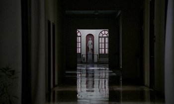 Movie still from “Nostalghia” (1983), directed by Andrei Tarkovsky – A hallway leading to a room that has a statue of a man in it; Extreme Wide shot, High angle