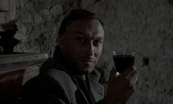 Movie still from “Nostalghia” (1983), directed by Andrei Tarkovsky – A man holding a glass of wine in his hand; Close Up shot, High angle