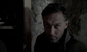 Movie still from “Nostalghia” (1983), directed by Andrei Tarkovsky – A person wearing a jacket; Close Up shot, Over the shoulder angle