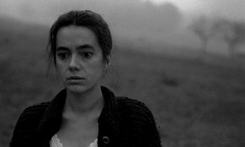 Movie still from “Nostalghia” (1983), directed by Andrei Tarkovsky – Black and white photograph of a woman in a field; Close Up shot, High angle