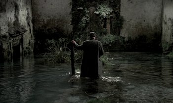 Movie still from “Nostalghia” (1983), directed by Andrei Tarkovsky – A man standing in the middle of a body of water; Wide shot, High angle