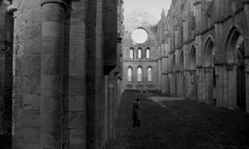 Movie still from “Nostalghia” (1983), directed by Andrei Tarkovsky – A man standing in the middle of an old building; Extreme Wide shot, High angle