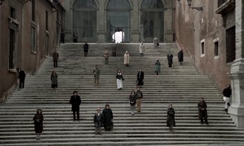 Movie still from “Nostalghia” (1983), directed by Andrei Tarkovsky – A group of people standing on a set of stairs; Extreme Wide shot, High angle