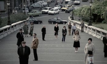 Movie still from “Nostalghia” (1983), directed by Andrei Tarkovsky – A group of people standing on the side of a road; Extreme Wide shot, High angle